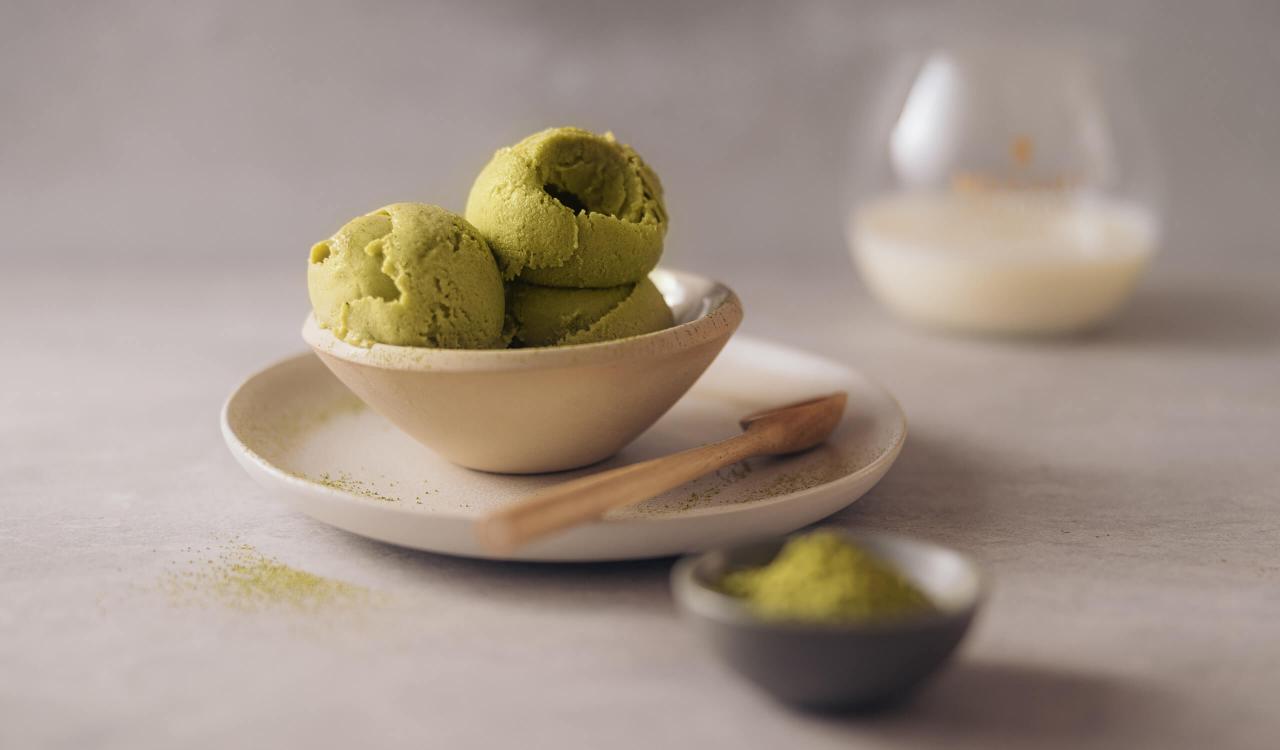 Mozart Matcha-Eis mit Mozart Coconut Chocolate Tumbler Glas im Hintergrund