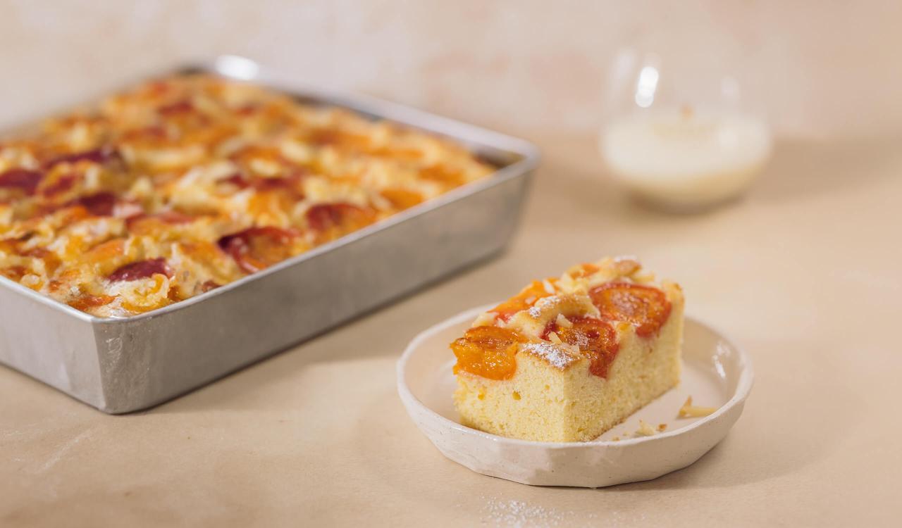 Ein Stück Mozart Marillen-Blechkuchen mit Mozart White Chocolate Liqueur Tumbler Glas